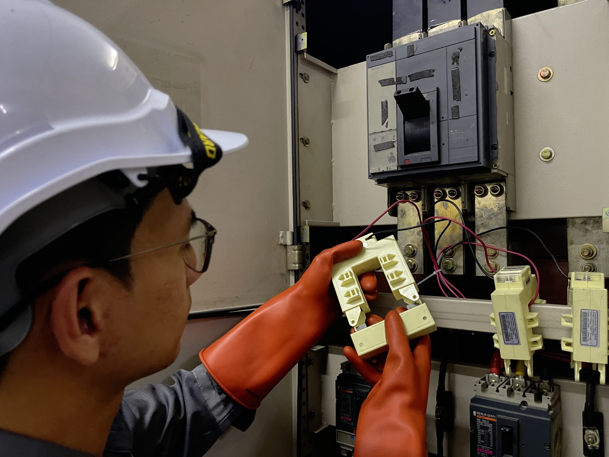 Technician carrying out electrical measurement at a distribution panel · original MyEnergy website photograph